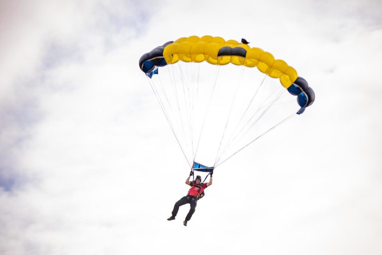 A member of the U.S. Navy Leap Frogs Parachute Team floats down to the Auraria Campus in downtown Denver