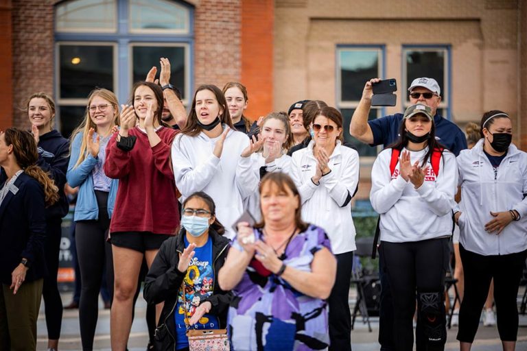 Members of the MSU Denver women's volleyball team cheer on the U.S. Navy skydivers who dropped in on the Auraria campus 
