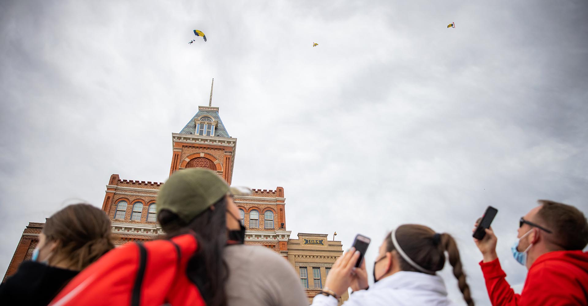 Photo of bystanders watching Leap Frogs parachuting on the Auraria campus