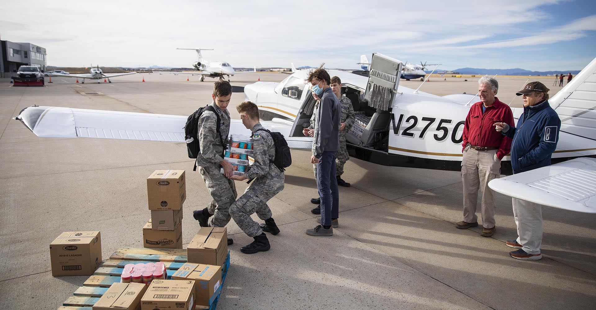 Photo of pilots loading donated items into a plane
