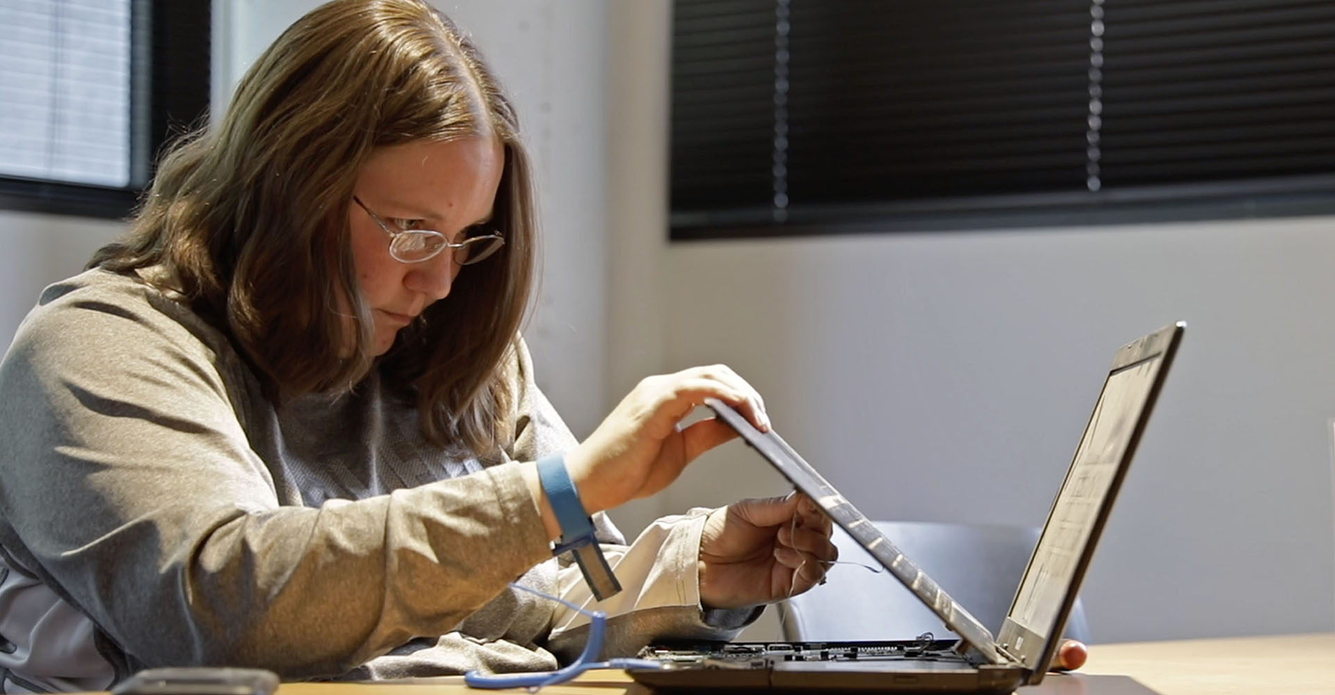 Photo of Jenn Cassidy repairing a computer