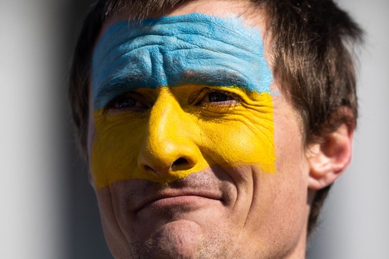 Photo of a protestor at a recent Pro-Ukrainian rally in Denver with the Ukrainian flag colors painted on his face.