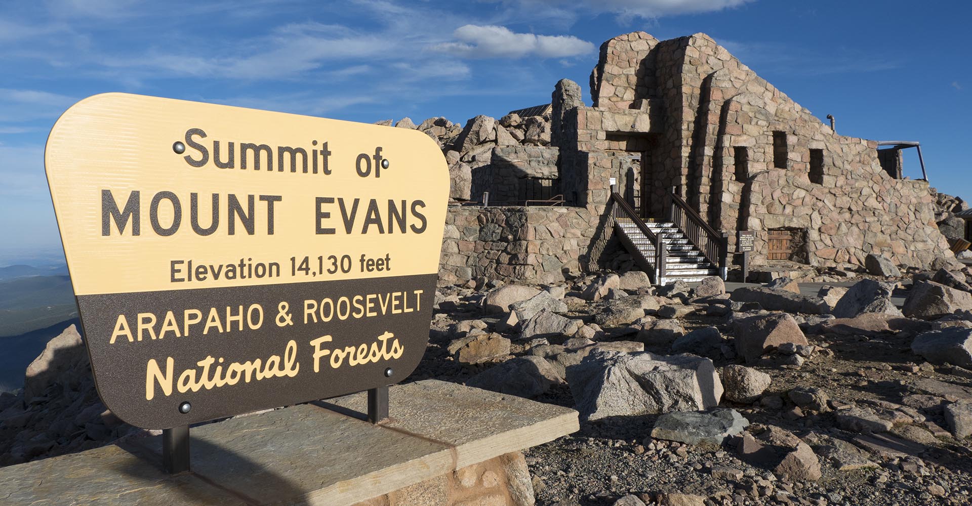 Photo of the Mt. Evans summit with sign and brick structure