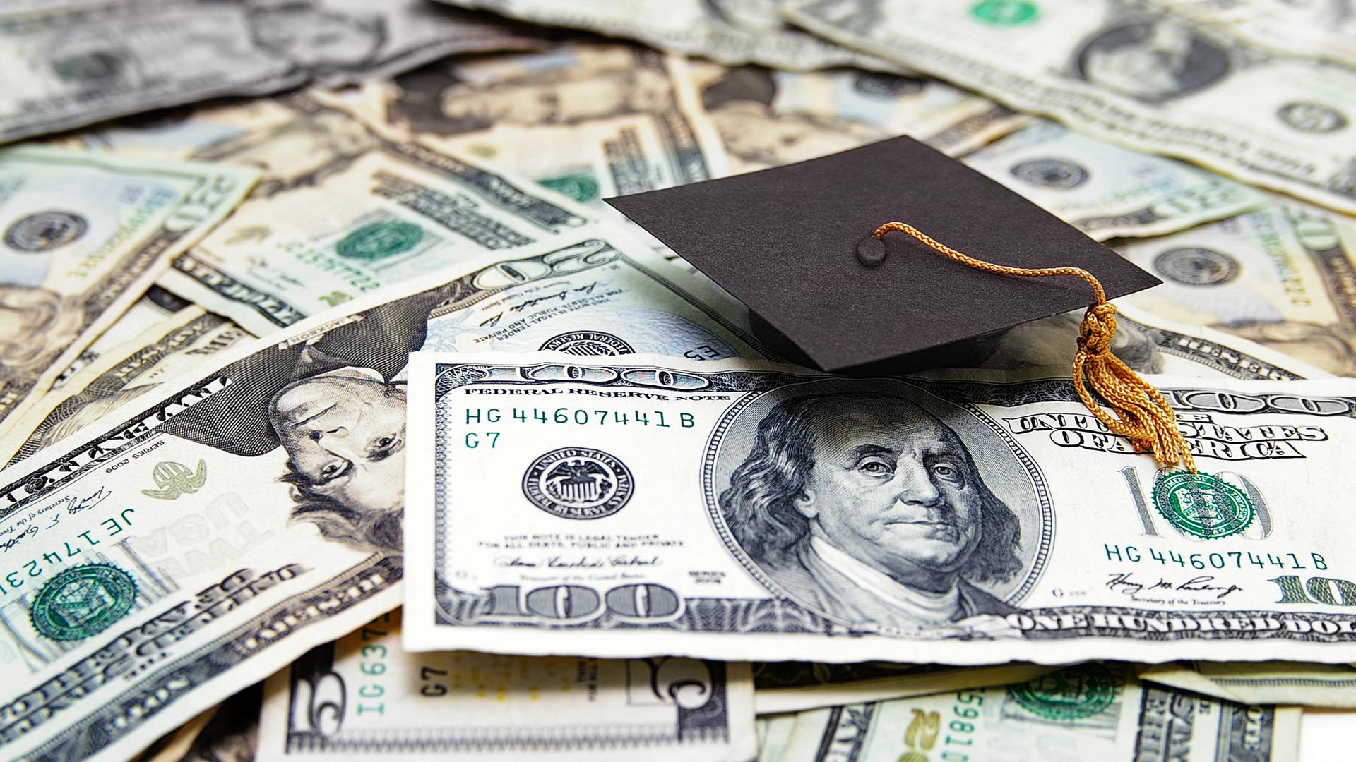 Money bills and graduation cap