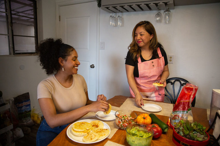 Thalia Rodriguez (dešinėje) ir Ines Calvete Barrios (kairėje) susėda sveikai pavalgyti arepų, piko, šviežių daržovių ir gvakamolės.