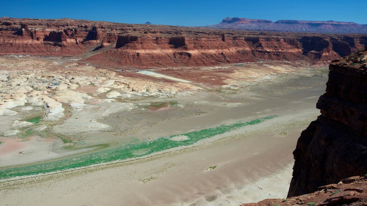 The Colorado River and the dried up arm of Lake Powell at Hite, Utah, with the landlocked boat launch now far from the river, a result of years of drought.