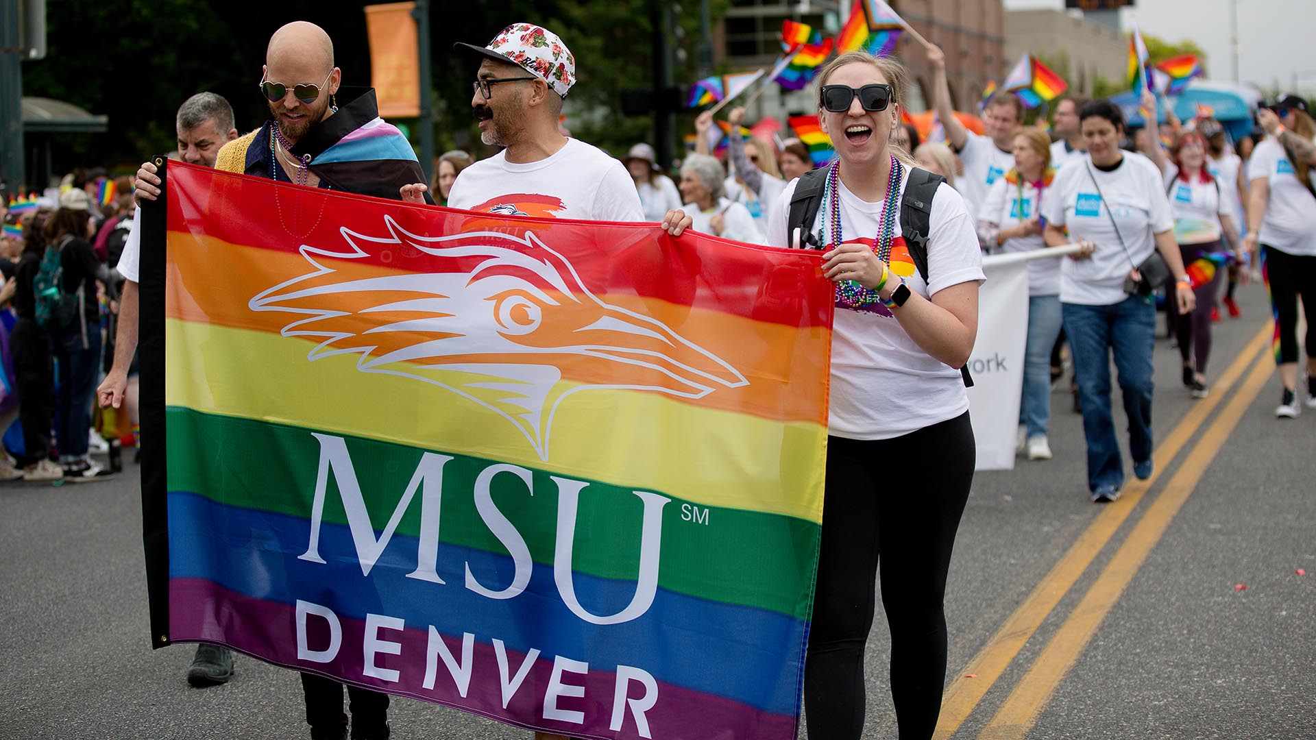 Kiel Oberlander, Damen Glover and Sarah Hunsinger lead MSU Denver's group in the Denver Pride Parade.