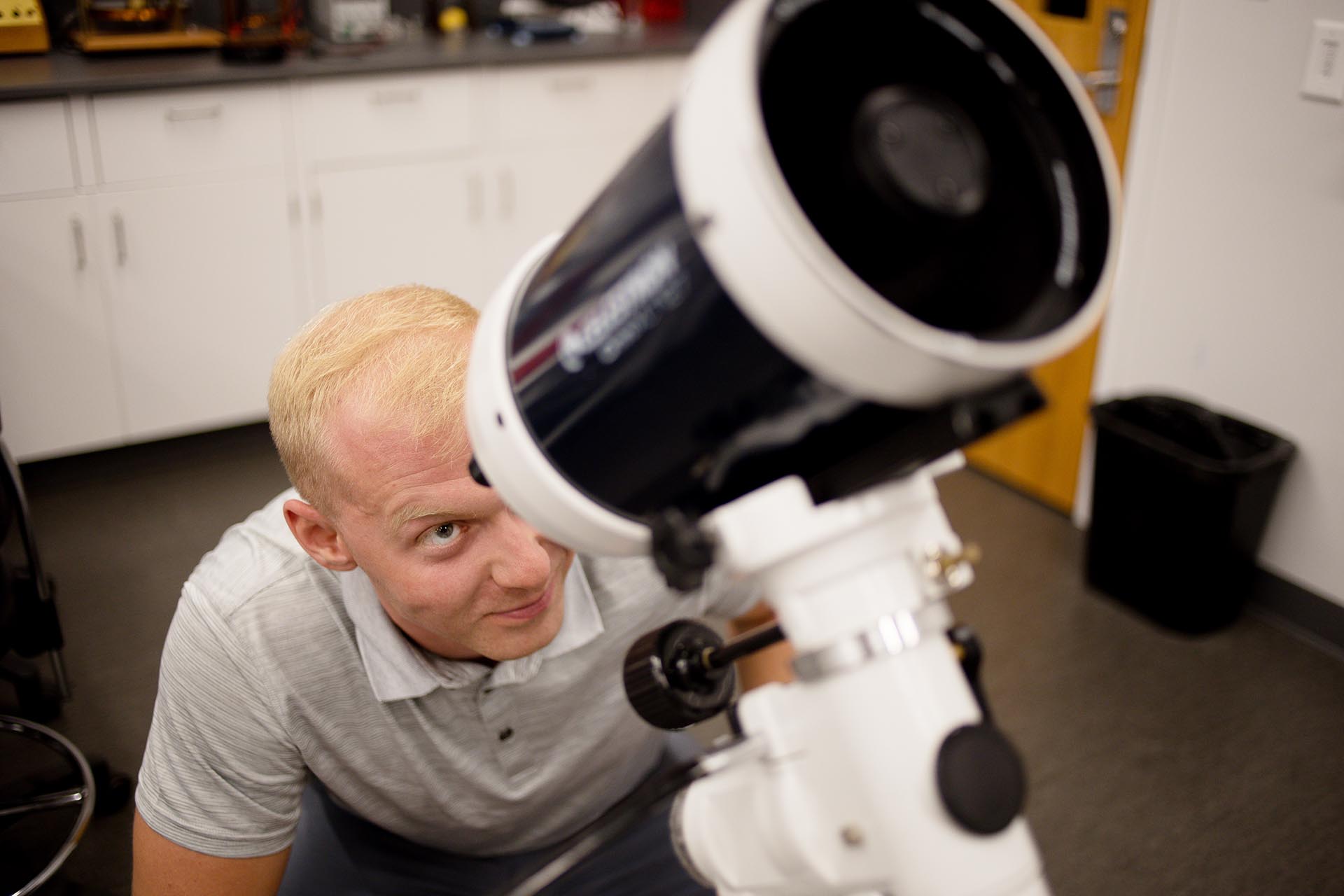 MSU Denver student Cody Ward takes a look in the Celestron Omni XLT 127 Telescope in the Physics Laboratory