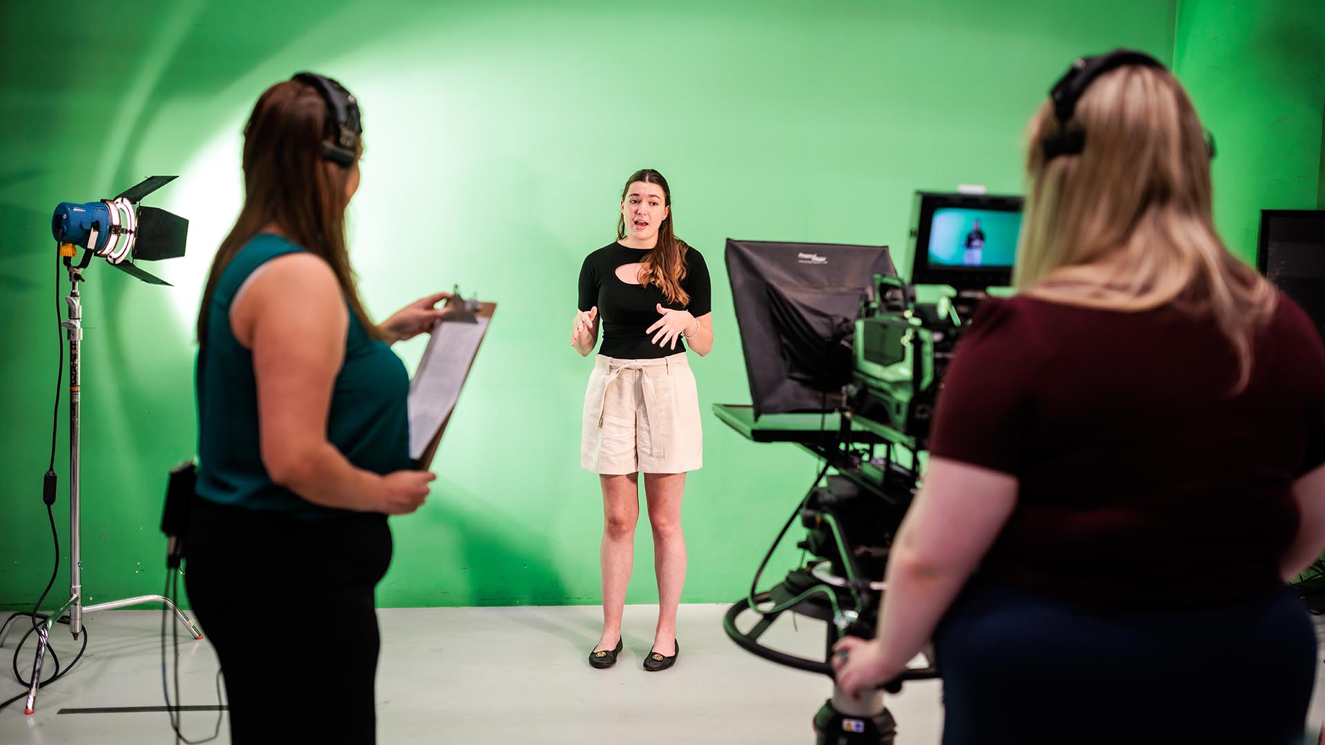 MSU Denver journalism students, Reanna Medina reports as Tiffani Hernandez, left, produces and Sara Martin, right, works the camera in the studio at the Auraria Media Center.