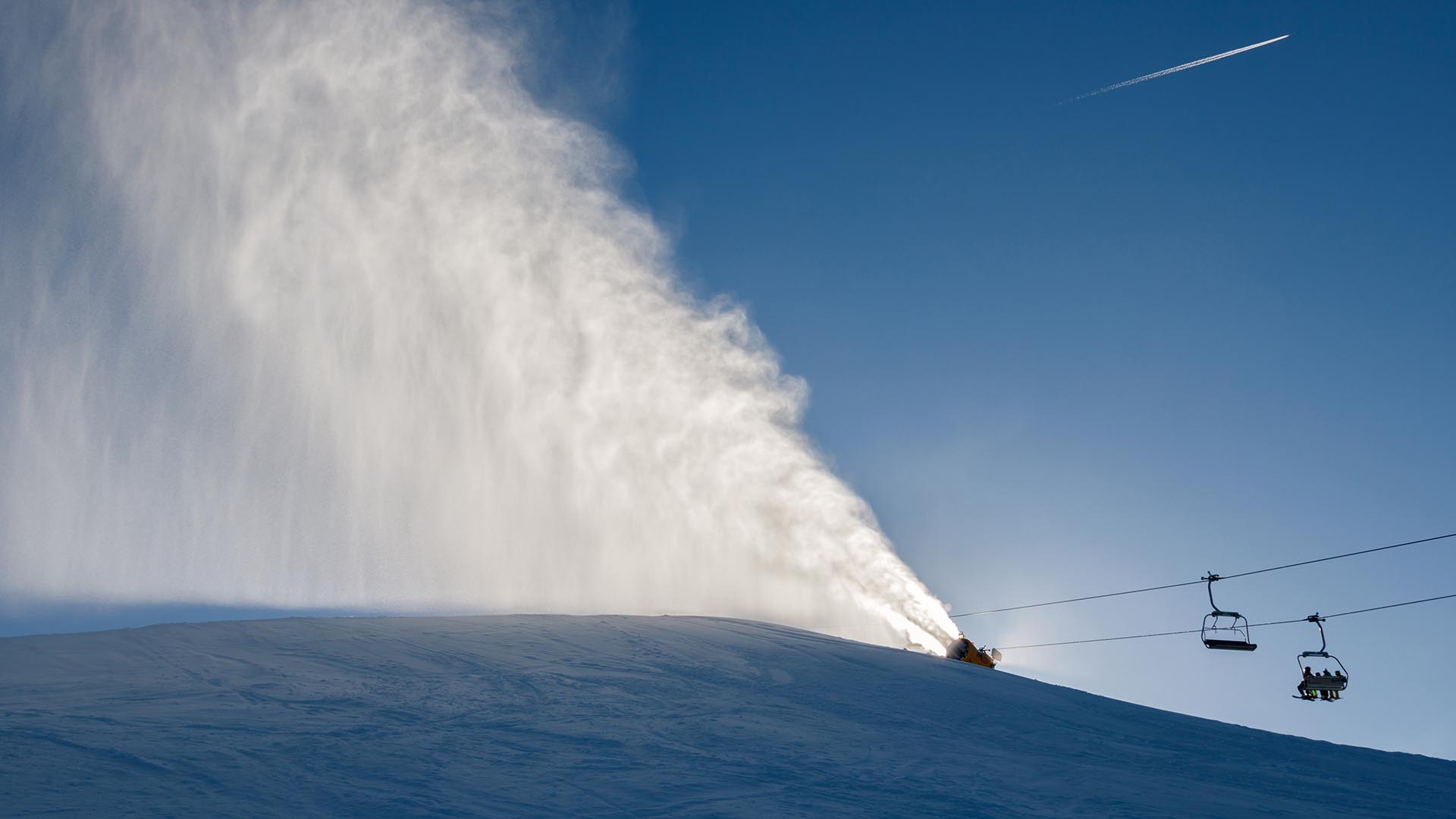 Snow cannon and chairlift at ski resort