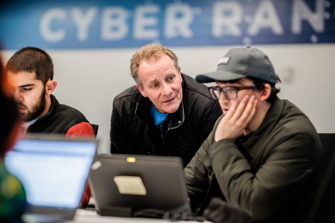 MSU Denver’s Director of the Cybersecurity Center, Richard MacNamee, works with student Adonis Nieves