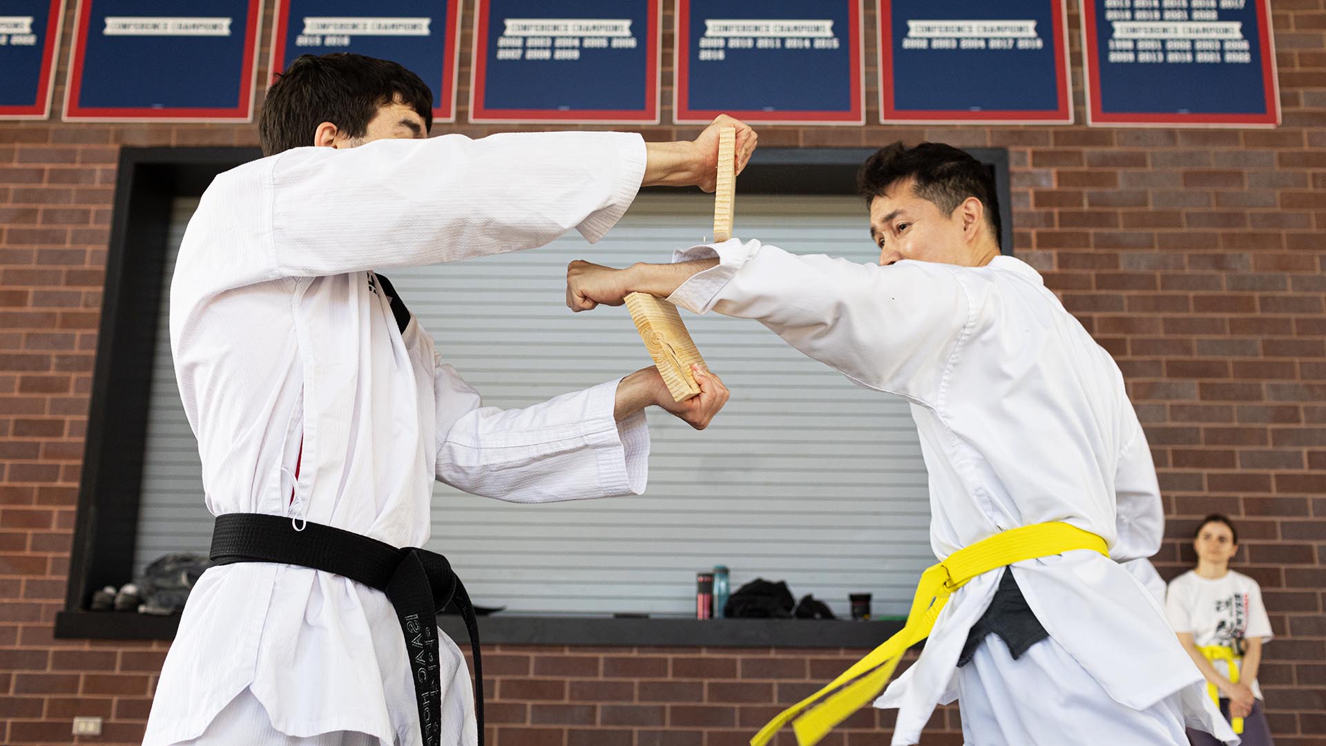 Abraham Gutierrez Rodriguez, right, breaks a board held by Isaac Hoffer at taekwondo class