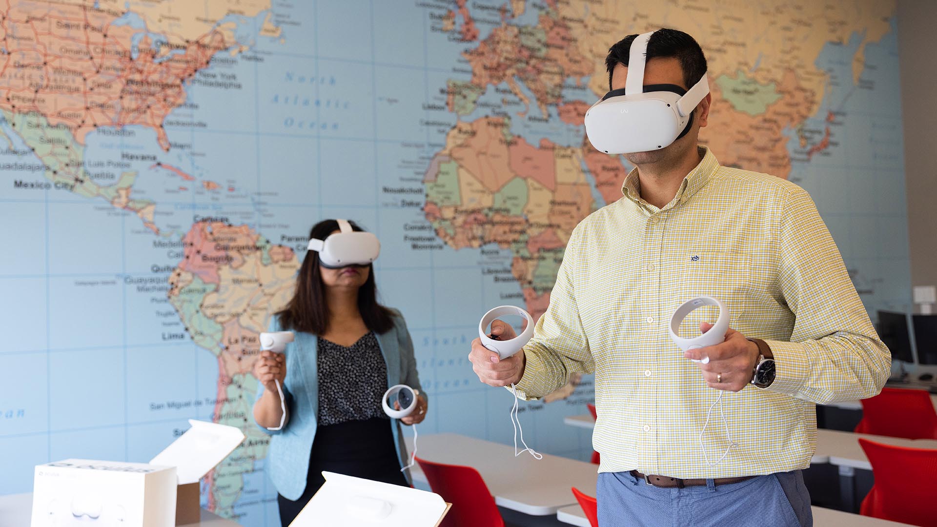 School of Hospitality professors Smita Singh, left, and Kiyan Shafieizadeh try out the Oculus virtual reality goggles