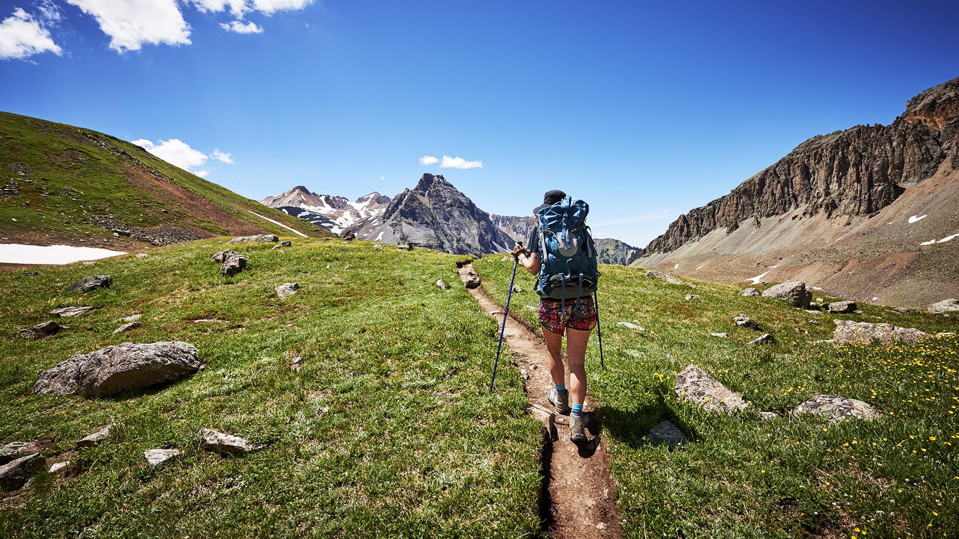 A young woman hiking with backpack in the mountains