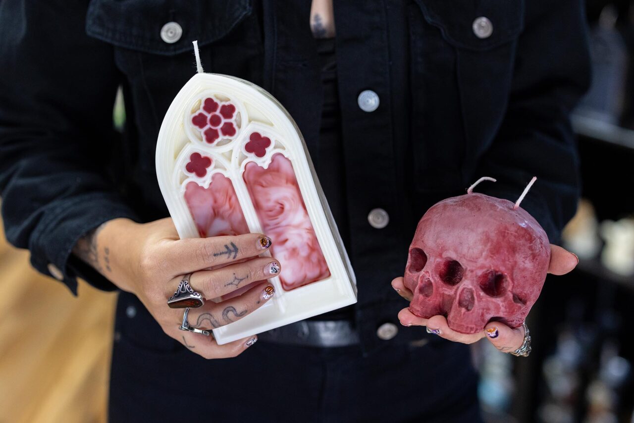 Emerald Boes, owner of HORRID brand at her shop holds molded candles for Halloween season.