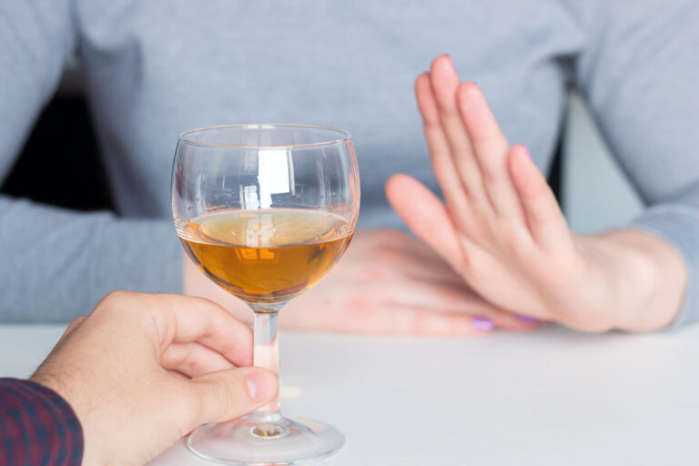 Glass of alcohol refused by a hand
