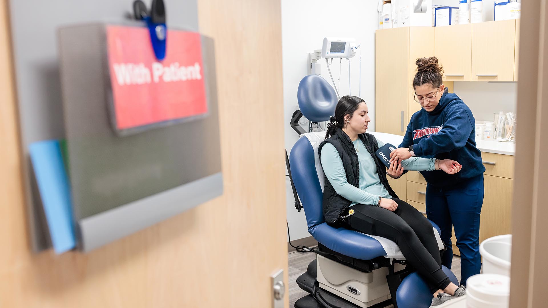 MSU Denver student Julianna Montoya, checks the blood pressure of a patient