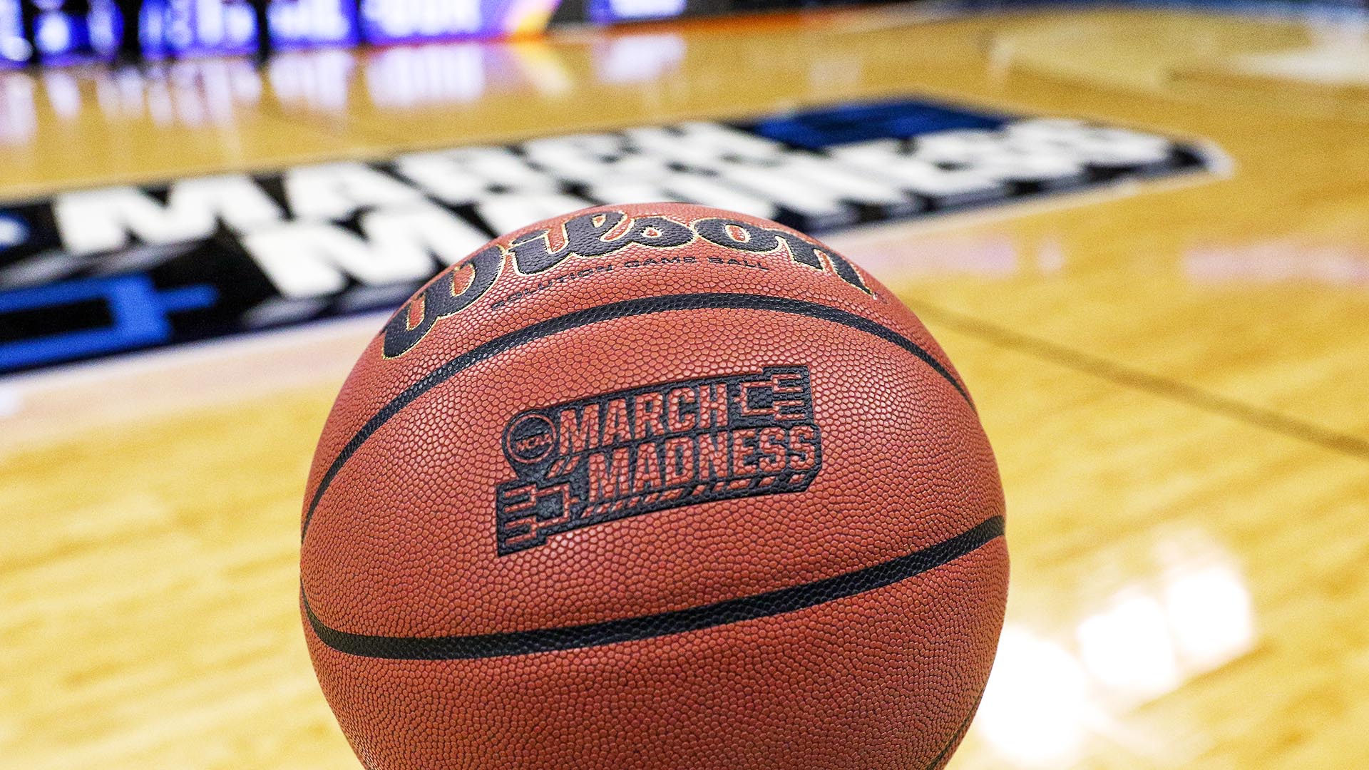 A game ball with the NCAA tournament logo in the background