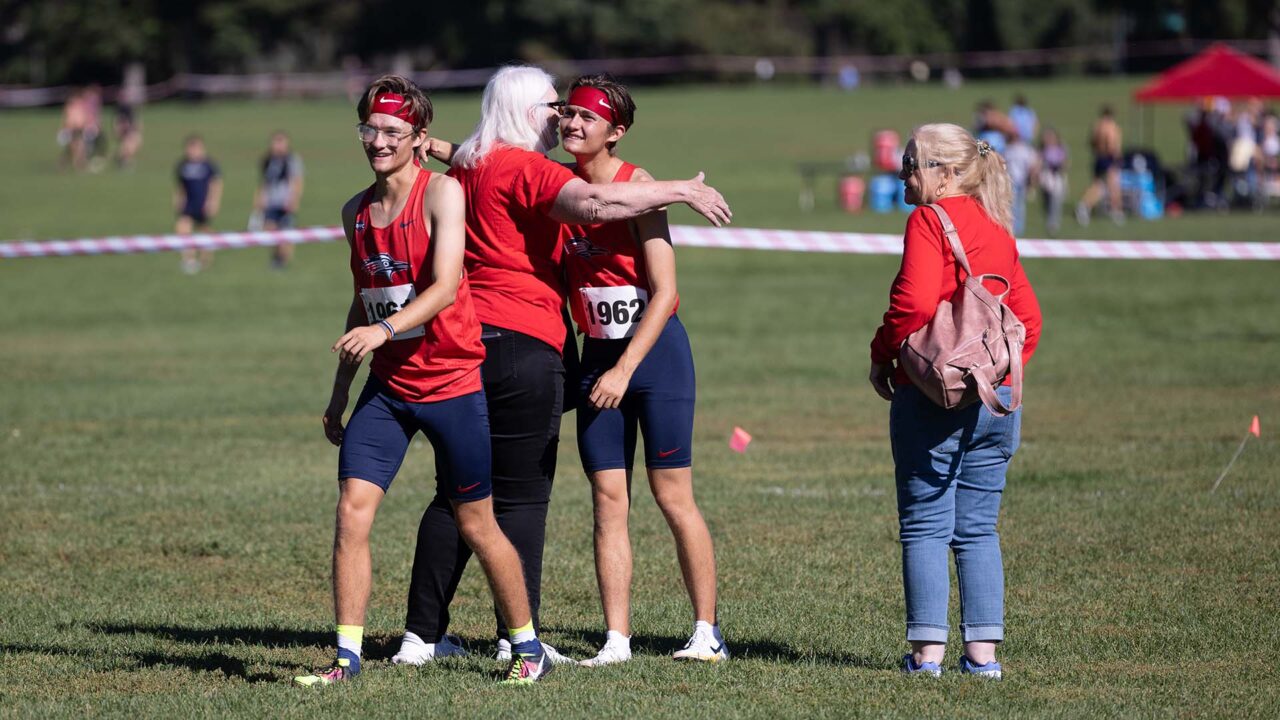 Jonathan and Jordan Duran hug family at their cross country race at Washington Park in Denver