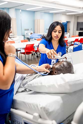 MSU Denver nursing student Jimena Malta takes the temperature of a mannequin