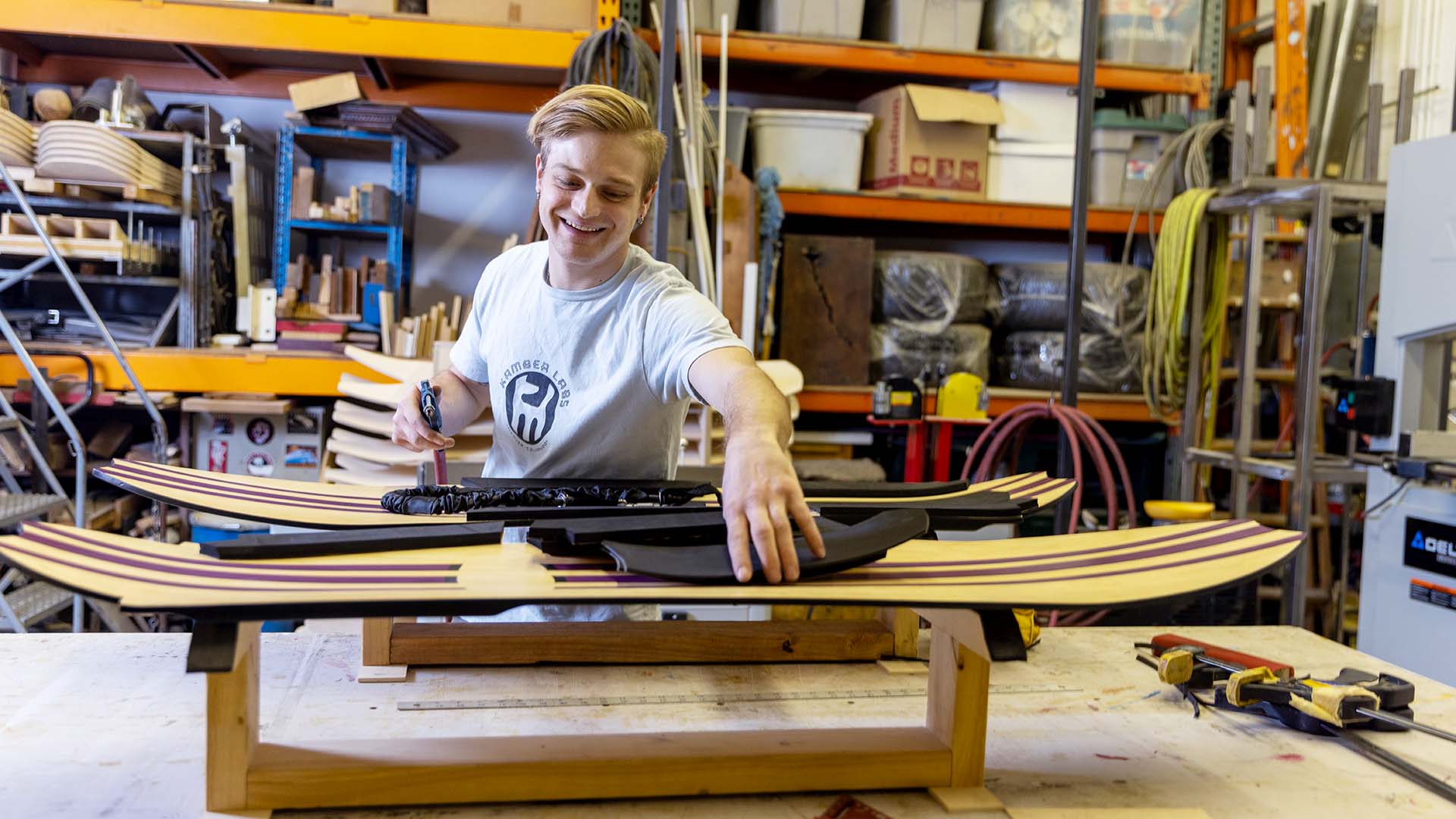 MSU Denver industrial design student Quinn Aiello puts grip on snowboards at his design shop in Denver. Aiello founded Kamber Labs in 2021.