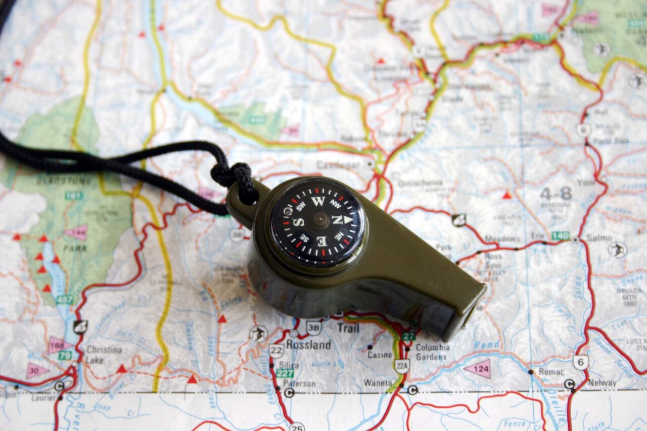 A multiuse whistle and a hiking map.