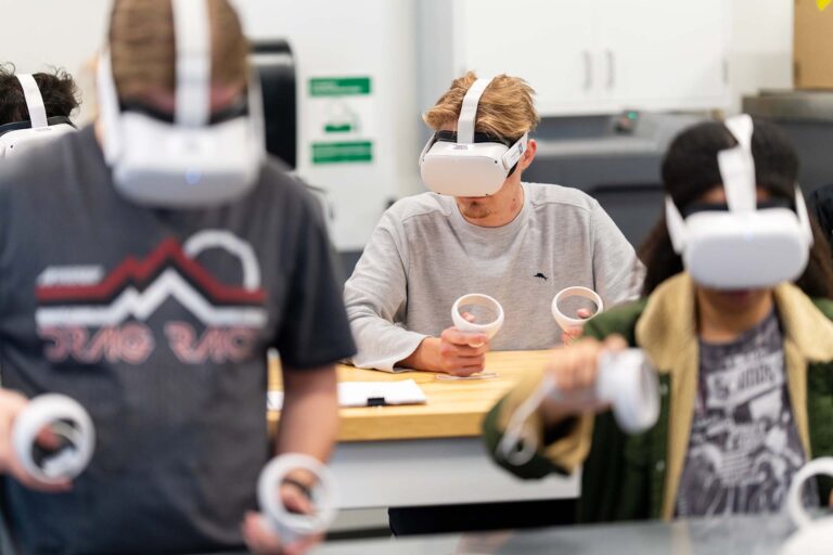 Advanced Manufacturing students use virtual reality headsets to practice precision measurement skills in a training simulation.