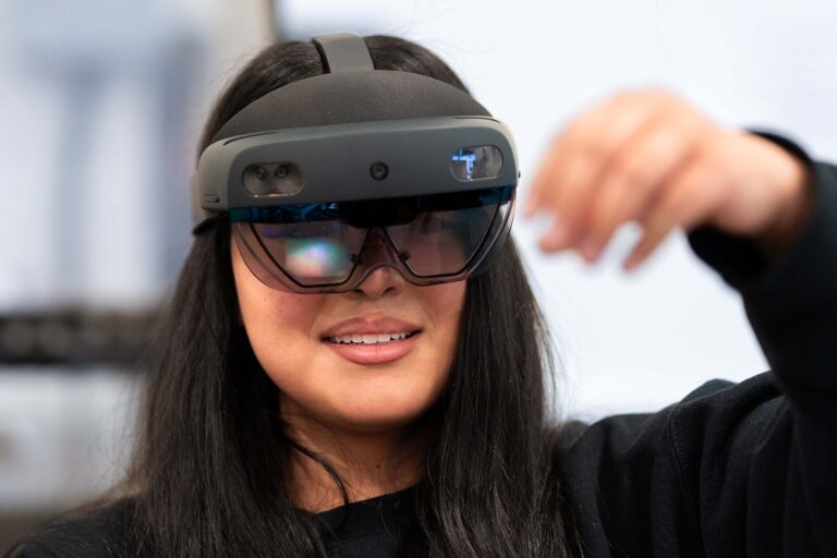 Advanced Manufacturing student Brissa Arredondo uses an augmented reality headset to interact with 3D models projected in the room.