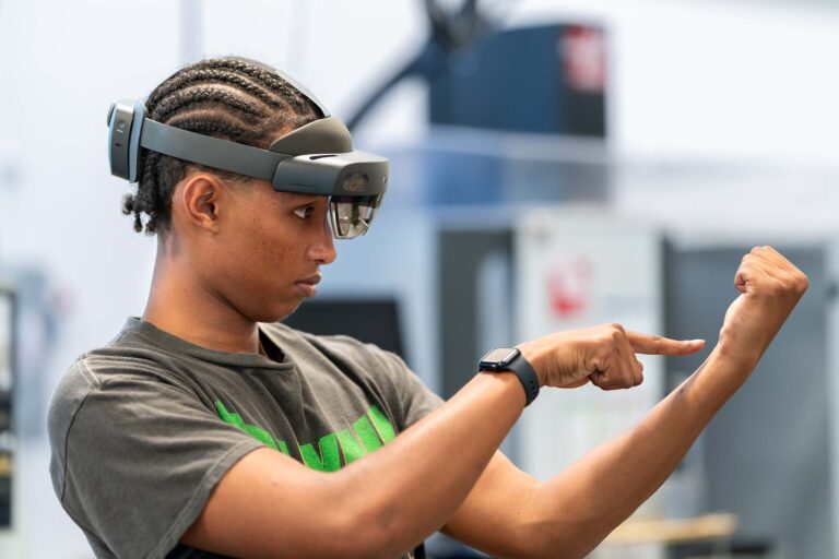 MSU Denver advanced manufacturing student Ebenezer Worku uses an augmented reality headset to interact with 3D models projected in the room
