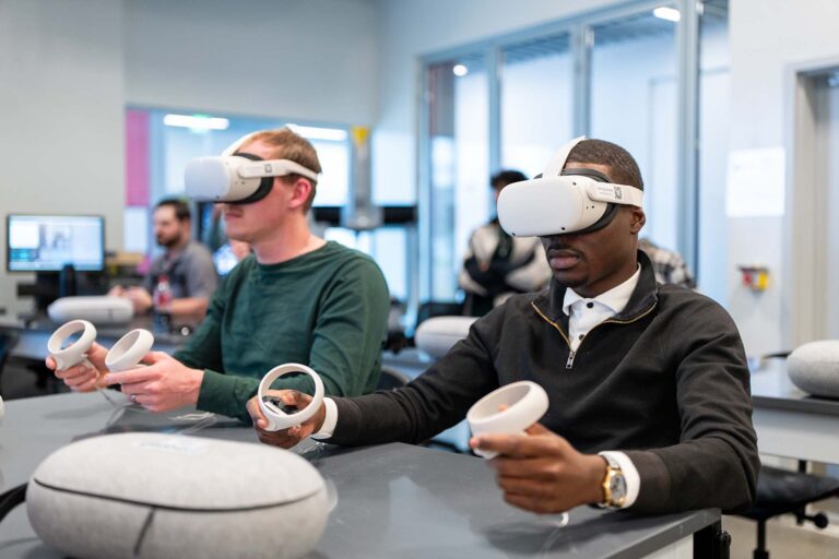 Advanced manufacturing students David Ranta, left, and Faisal Kaweesause use virtual reality headsets