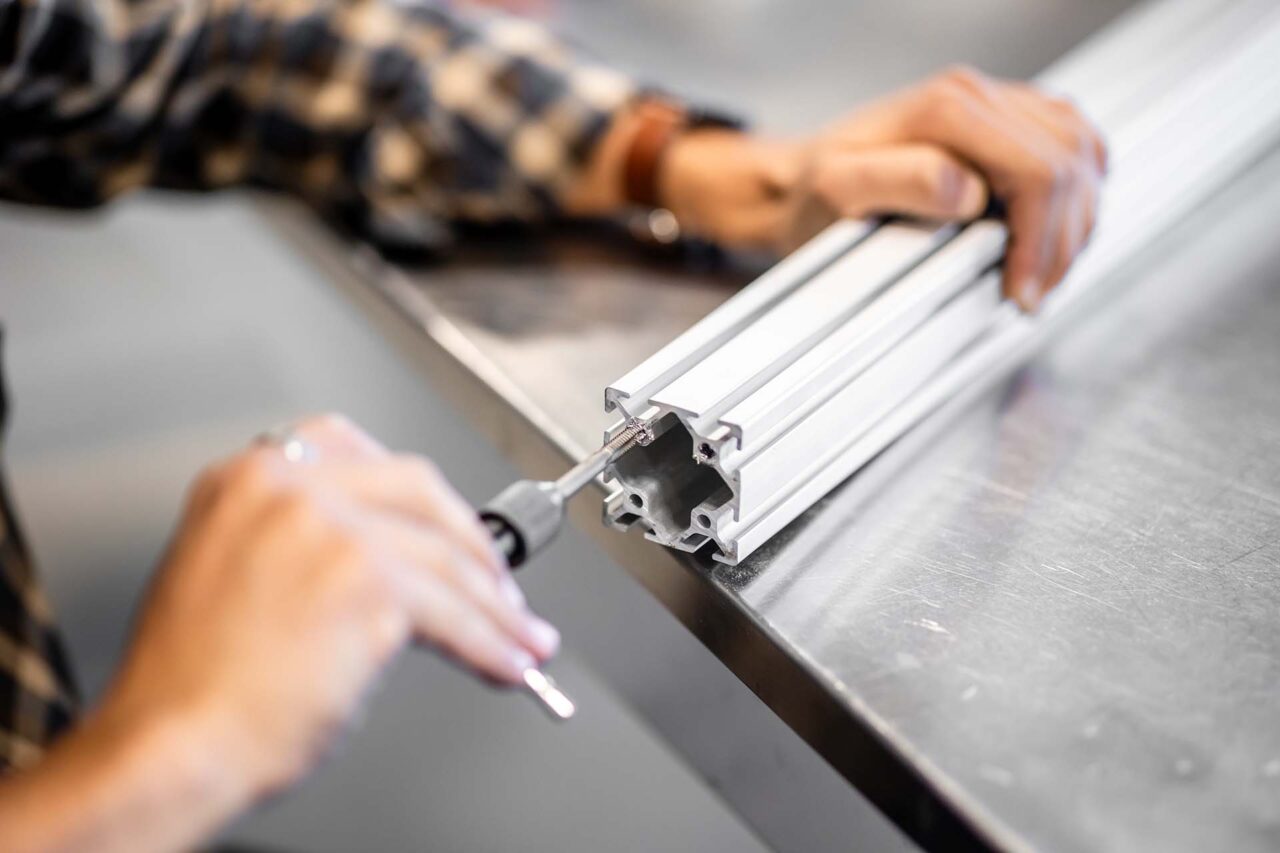 Marco Antonacci taps the ends of the aluminum in preparation to start assembling the frame jig.