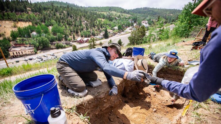 MSU Denver anthropology student Jeremy Davis is handed an artifact
