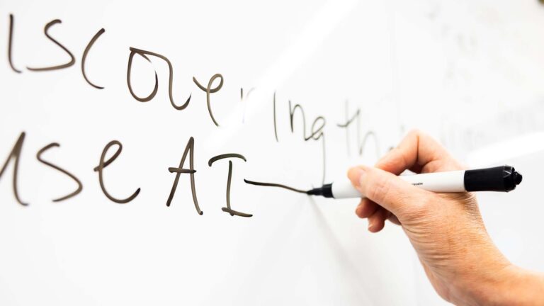 Hand using marker to write on white board