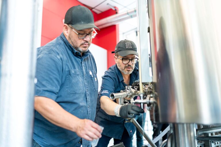 Professor Bernardo Alatorre demonstrates to brewing student Ricardo Jim Puente how to gather and test a sample.