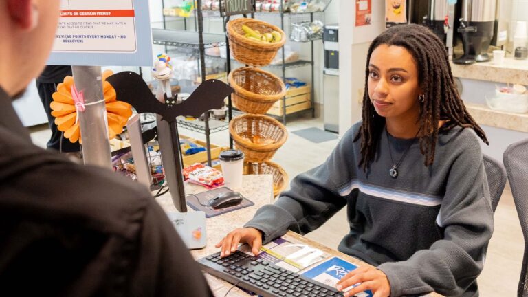 MSU Denver student Meley Hagos checks out a student at Rowdy's Corner.