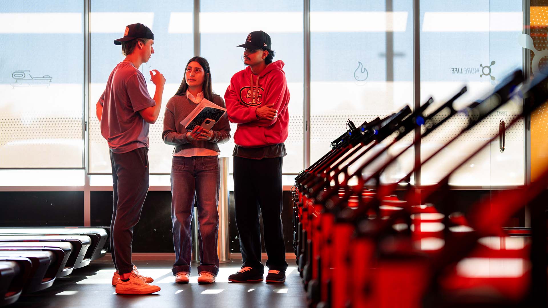 MSU Denver students from left to right Jaden Tomalin, Jasmine Quinones and Barry Vera inspect treadmills at the Orangetheory Fitness location in Edgewater