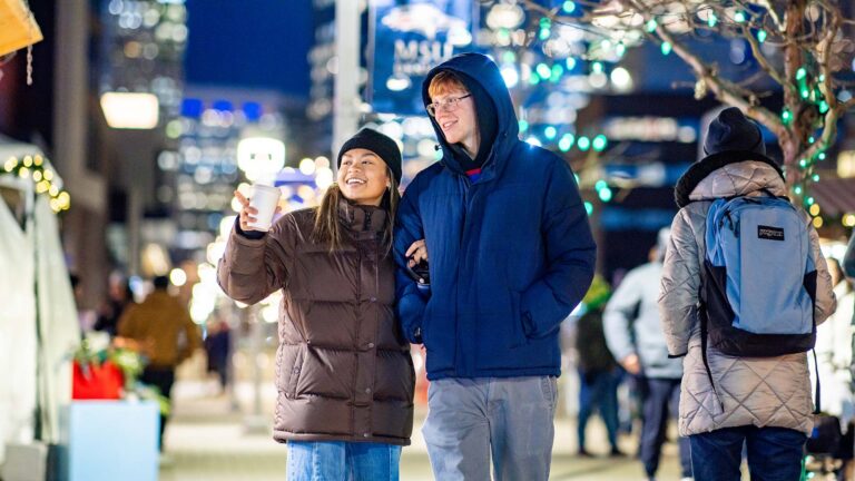 MSU Denver student Anissa Mohd Reza and alum Noah Block walk through the Denver Christkindlmarket