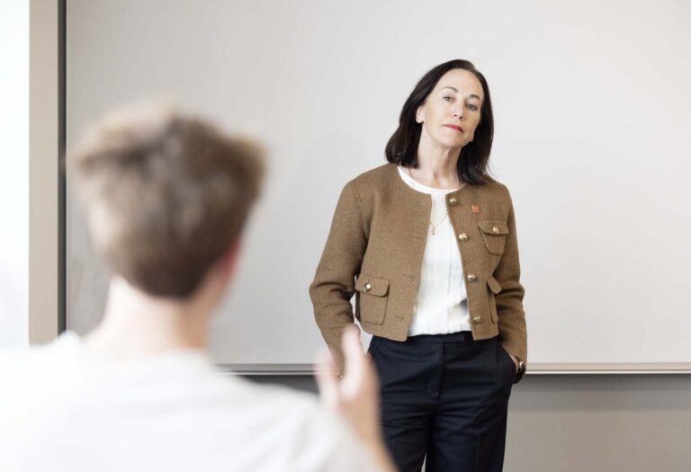 President Janine Davidson, Ph.D., listens to a student speak during her class.