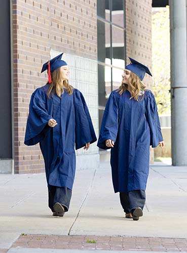 Twins Mariya, left, and Polina Giganova try out their commencement gowns.