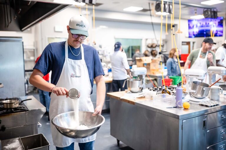 MSU Denver student Ryan Evans measures ingredients for cupcakes