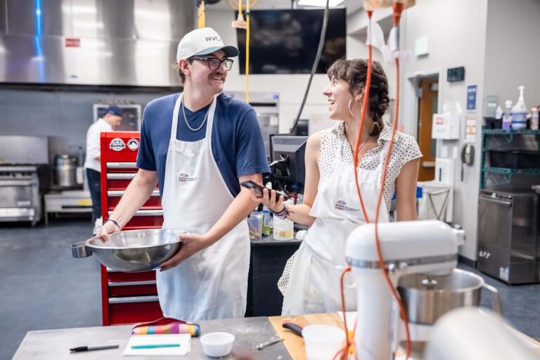 MSU Denver student Ryan Evans talks to classmate Camila Hernandez in a Basic Baking Skills class