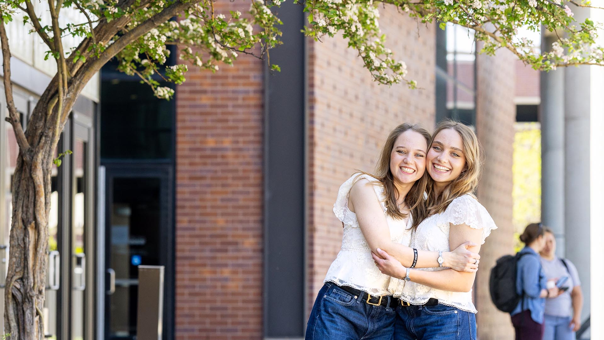 Identical twins graduate side by side with accounting degrees