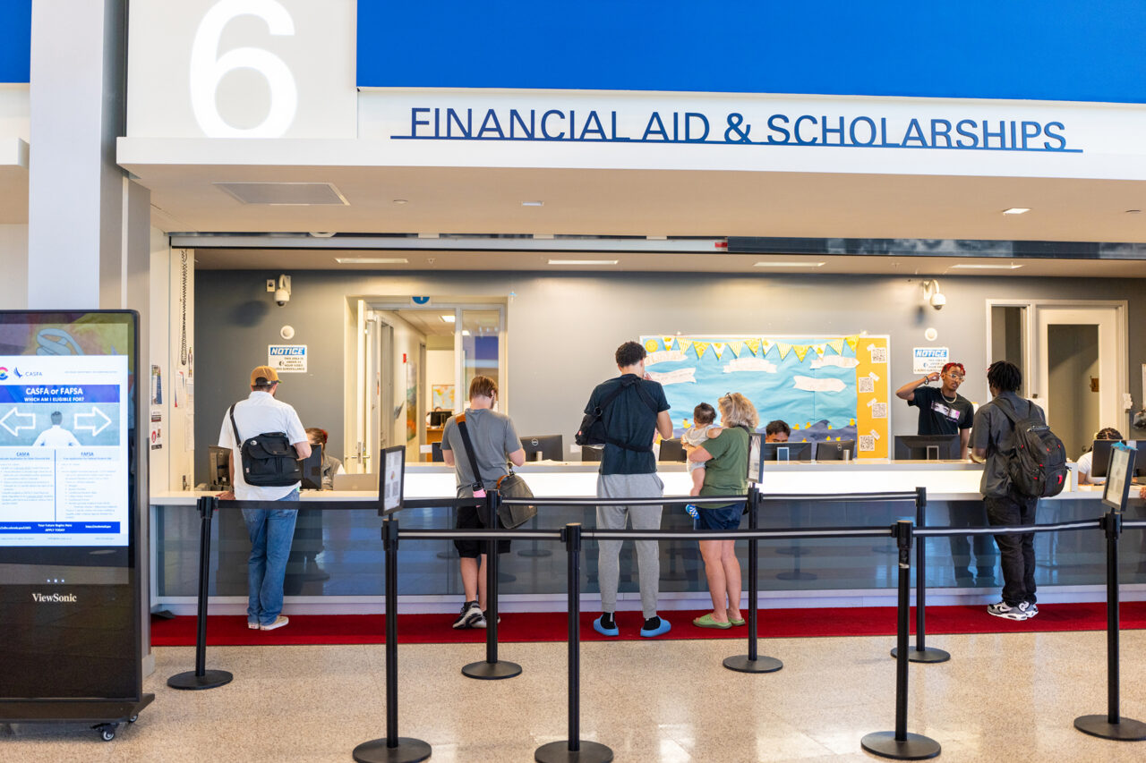 Students stand at the Financial Aid and Scholarships counter at MSU Denver