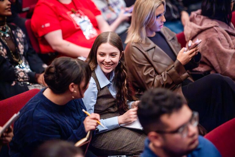 An attendee smiles in the audience before the debate.